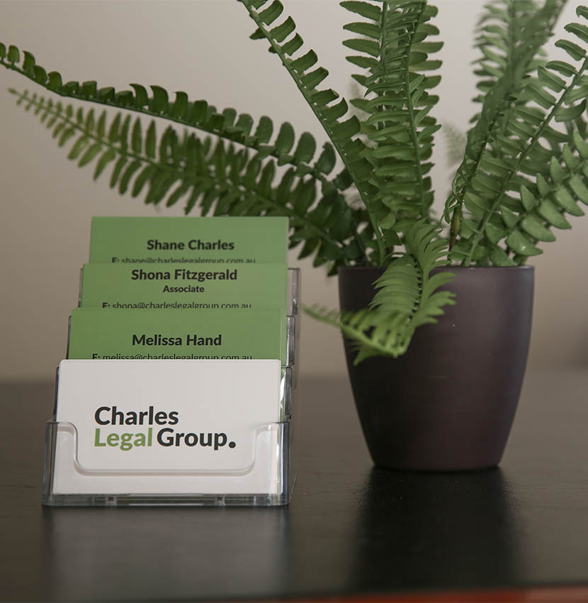 Close up of Charles Legal Group business cards on reception counter